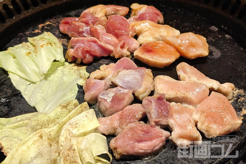 溶岩焼きプレートに鶏肉（塩味・タレ味）をのせて焼いている写真