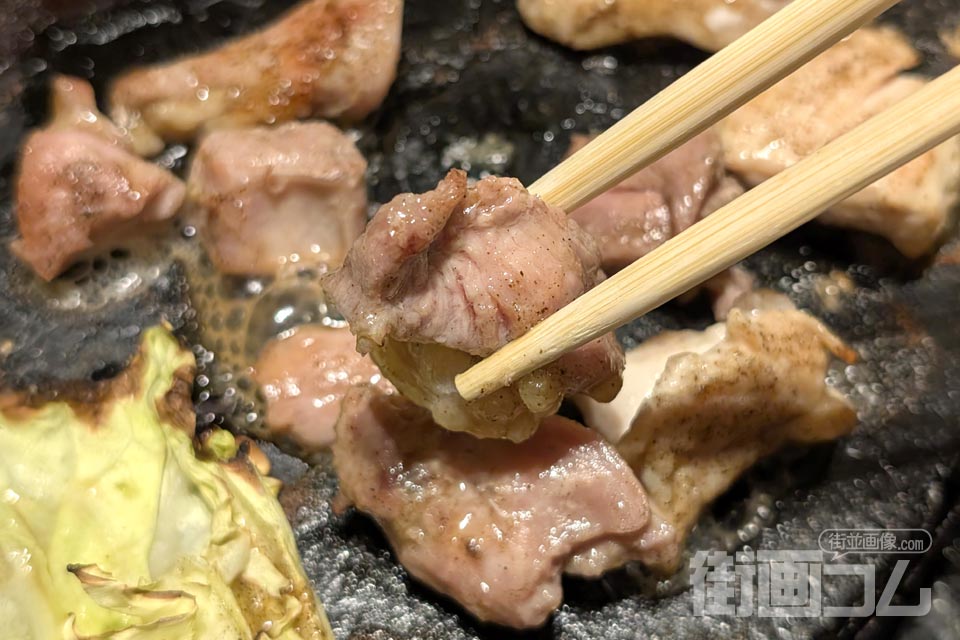 焼けた塩味のもも肉を箸でリフト