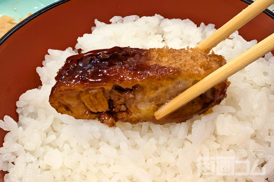 「とんかつソース」をつけた黒豚ロースカツをごはんにのせた写真
