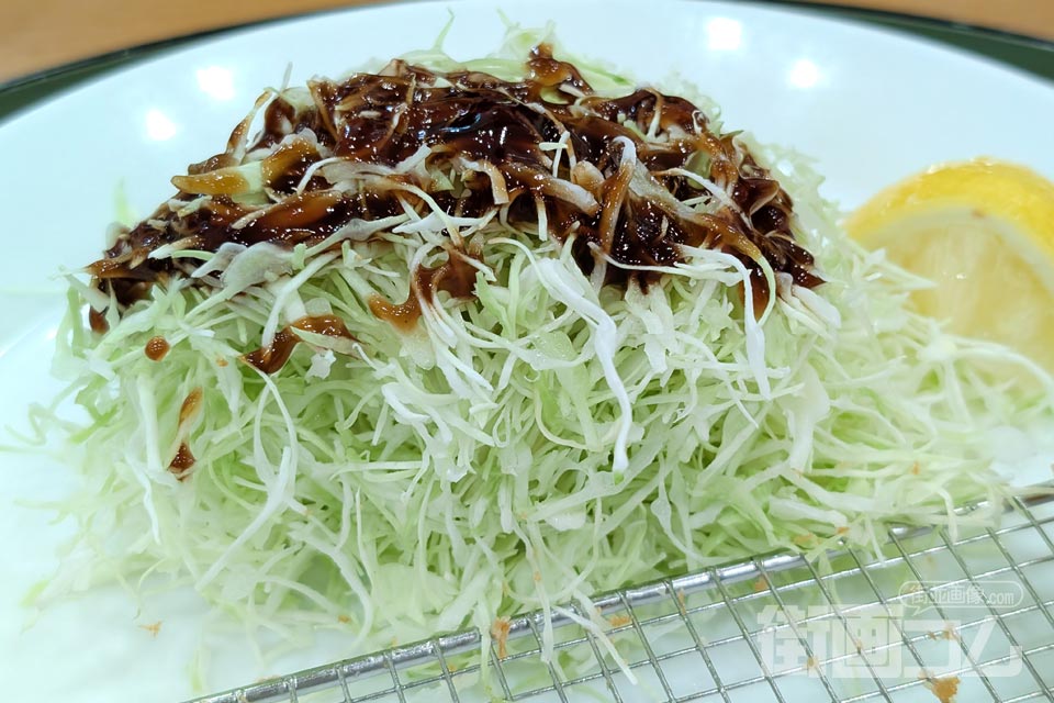 定食のキャベツにソースをかけた写真