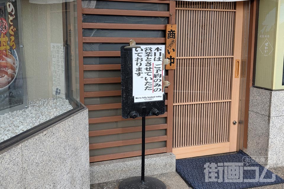 店頭の「本日はご予約のみの営業とさせていただいております。」の表示が貼られた看板