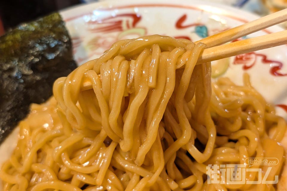 タレが絡んだ黒丸油そばの麺を箸で持ち上げたところ