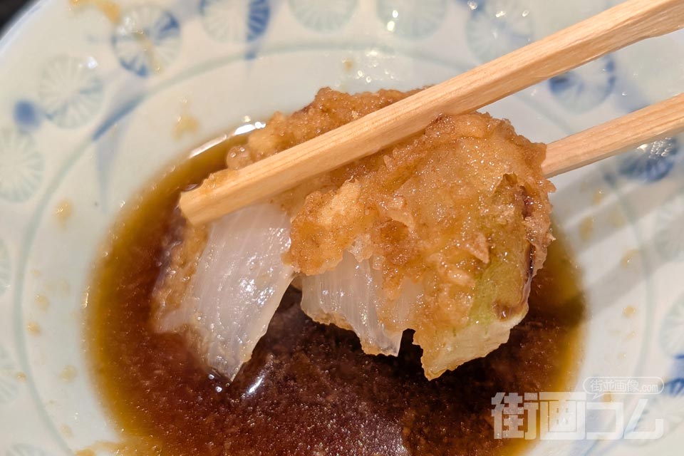 玉ねぎの天ぷらを大根おろし入りの天つゆにつける