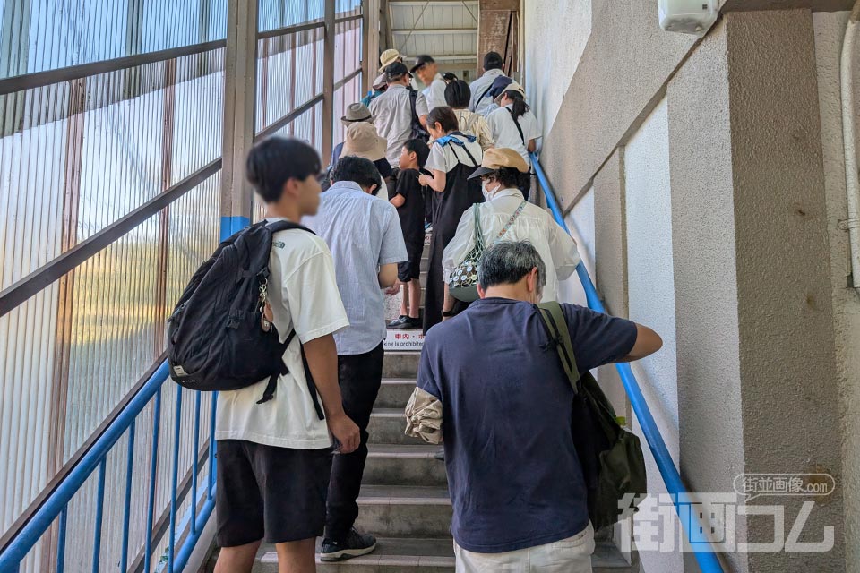 山麓駅の改札へ続く階段に並ぶ乗車待ちの列