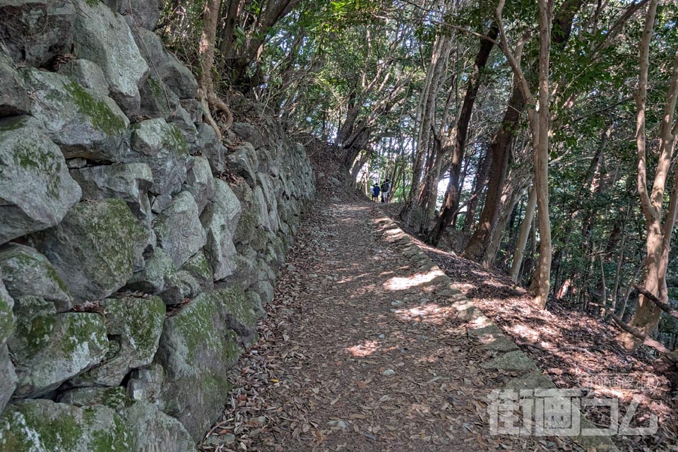大きな石が積まれた石垣と山道